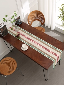Detail of woven table runner featuring geometric wave patterns and handcrafted tassels