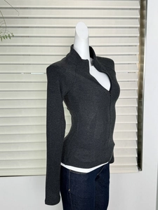 Side view of dark grey slim-fit zip-up thermal top with high collar on a mannequin