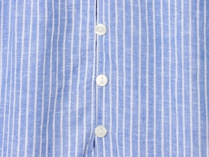 Gros plan d'une chemise en coton à rayures bleues et blanches montrant le tissu