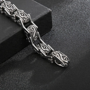 Close-up of vintage silver floral engraved steel link bracelet on dark gift box