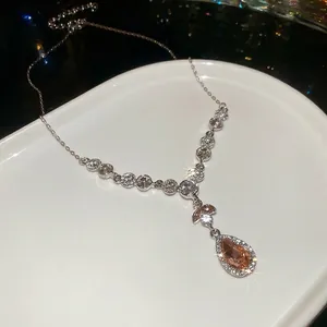 Elegante silberne Halskette mit bernsteinfarbenem Anhänger und Zirkonia in Keramikschale