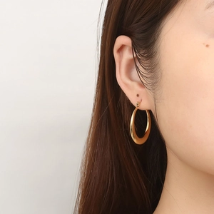 Classic 18K gold plated stainless steel hoop earrings worn by a female model