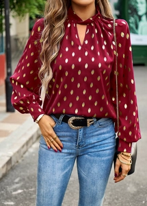 Detail of red lantern sleeve blouse with golden leaf print and halter V-neckline