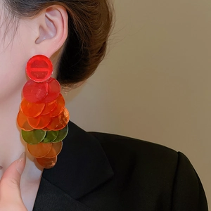 Close-up of colorful layered sequin tassel earrings with gradient acrylic discs