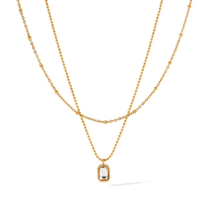 Detail of double-layer gold necklace featuring a rectangular zircon pendant and beaded chains