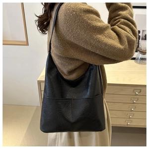 Lifestyle shot of large black leather tote bag showing soft texture and relaxed fit