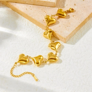Detail of a golden heart link bracelet in stainless steel with a lobster clasp closure
