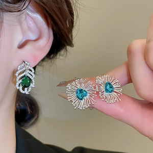 Détail de boucles d'oreilles en argent avec oxydes de zirconium poire verts et cœur bleus