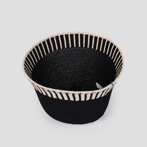 Detail view of black knit bucket hat featuring white vertical stripes and inner care label