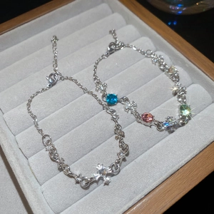 Detailed macro shot of cross charm bracelets with multi-color rhinestones on velvet