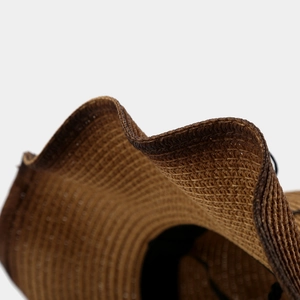 Brown woven western cowboy straw hat featuring wide wavy brim and detailed craftsmanship