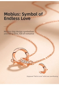 Macro shot of rose gold double ring necklace with 'Fall in Love' engraving and zircon