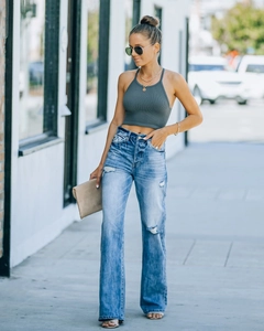 Streetstyle-Ansicht einer blauen High-Waist-Jeans mit weitem Bein und Rissdetails am Knie