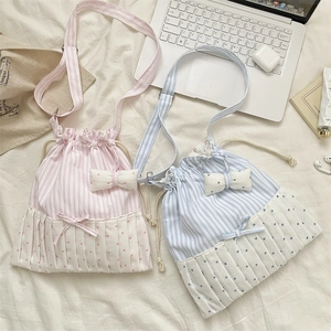 Detail of drawstring shoulder bag featuring pink and blue stripes with white pleated heart trim