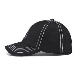 Detailed side view of black cotton baseball cap with white contrast stitching details