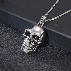 Macro shot of silver punk skull pendant with textured chain on a dark background
