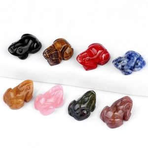 Hand-carved natural crystal and agate frog figurines in various gemstones on white background