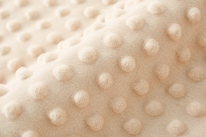 Vista macro della texture a pois sulla coperta beige per neonati in morbido tessuto