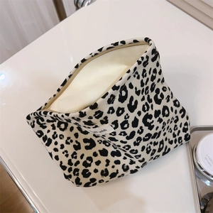 Detail of leopard print canvas makeup bag with woven label and cream inner lining