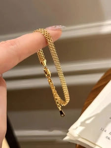 Dettaglio di bracciale a rete placcato oro 18K con trama intrecciata e chiusura a moschettone