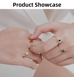 Close-up of gold-plated twisted rings featuring colorful teardrop stones on hand