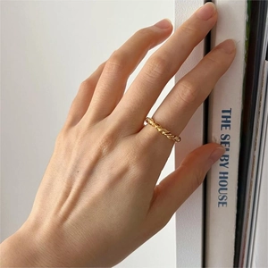 Close-up of a 925 silver knot ring in gold finish on a finger with a minimalist design