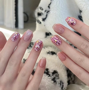 Detail of pink cat eye and glitter short square press-on nails on hands