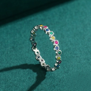 Macro side view of a colorful zircon eternity band with a polished silver finish