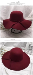 Close-up of wine red wide brim wool felt cloche hat featuring a matching bow decoration