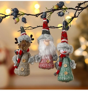 Close-up of knit reindeer, Santa, and snowman ornaments with wood buttons on a tree