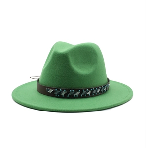 Detail of green wool fedora hat featuring a brown leather band with ethnic beadwork decoration