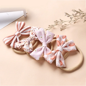 Set of four soft floral nylon headbands with cute bows for newborn baby girls