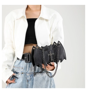 Detail of bat-shaped gothic crossbody bag featuring silver cross and chain decoration