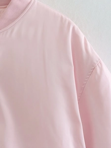 Close-up detail of pink jacket collar and shoulder seam showing fabric texture