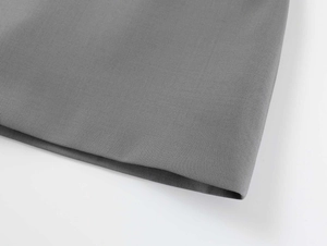 Detail view of dark grey woven fabric showing high-quality stitching on a mini skirt