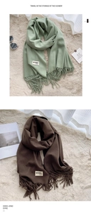 Detail of solid color scarves with soft fringe edges and minimalist brand fabric labels