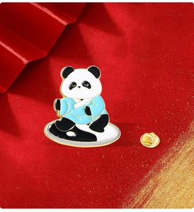 Detailed view of enamel panda brooch in blue Hanfu on Yin Yang base with red background