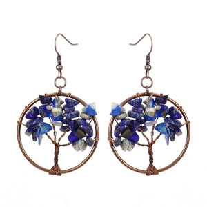Close-up of handmade Tree of Life wire wrapped earrings with blue natural crystal stones