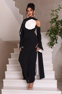 Detailed close-up of the 3D white flower ornament on a black off-shoulder formal gown