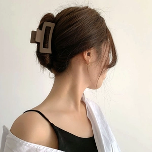 Braune matte rechteckige Haarklammer an Modell für sicheres Haarstyling gezeigt
