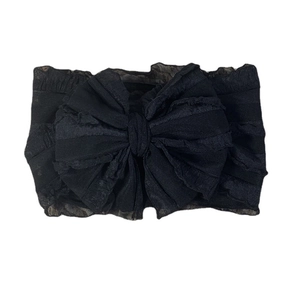 Detail of black lace baby headband with large mesh bow and ruffled edge decoration