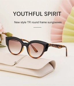Chic black and tortoiseshell cat-eye sunglasses on a cream storage box with decorative props