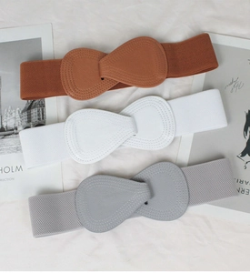 Detail of elastic waist belts for women in brown white and gray with faux leather buckles