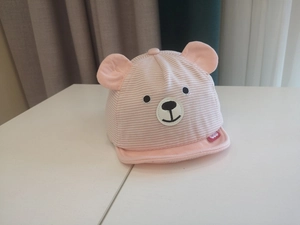 Close-up of pink and white striped baby baseball cap with cute bear ears and embroidery