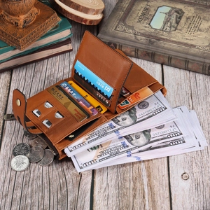 Vintage brown leather fold wallet with multiple card slots and snap button on wood desk