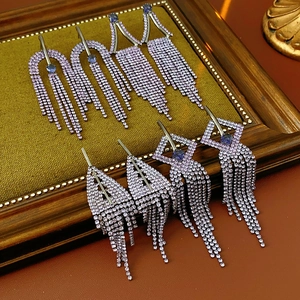 Detailed macro view of purple rhinestone tassel earrings with geometric silver frames