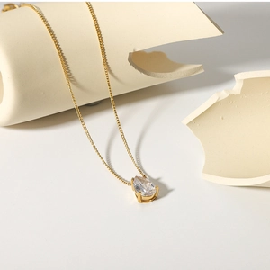 Detail of 18k gold plated necklace featuring a teardrop-shaped white zircon pendant
