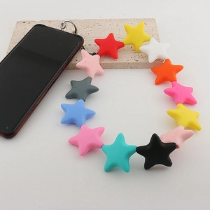 Close-up of colorful silicone star-shaped phone wrist strap with metal clasp on beige stone