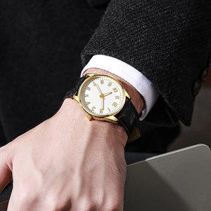 Dettaglio dell'orologio al quarzo dorato con quadrante bianco e cinturino in pelle nera