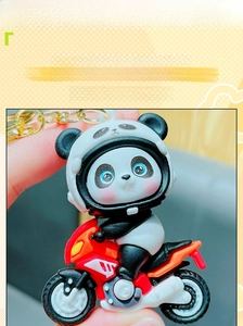 Close-up of creative 3D panda biker keychain featuring a red and black motorcycle toy